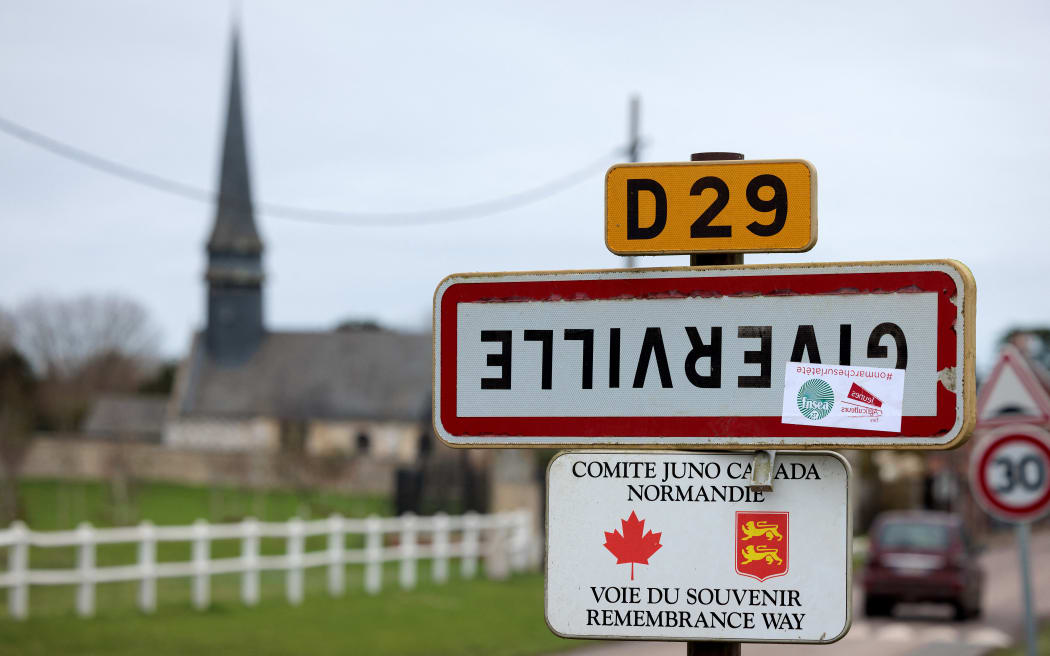 A photograph taken on December 7, 2023, shows a road sign indicating the entrance of the French town of Giverville, north-western France, which has been turned upside down as part of an action of FNSEA and Young Farmers unions to denounce an agriculture policy that “works on its head”. (Photo by JOEL SAGET / AFP)
