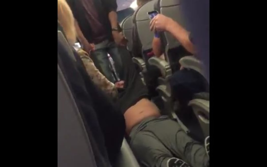 A screengrab from footage of the passenger being dragged from the plane.
