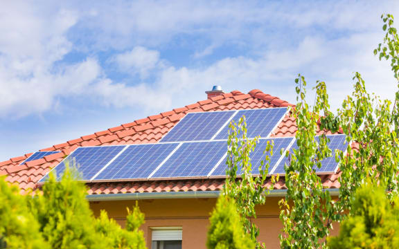 44317184 - solar panel cells on the roof of a new house agains blue sky.