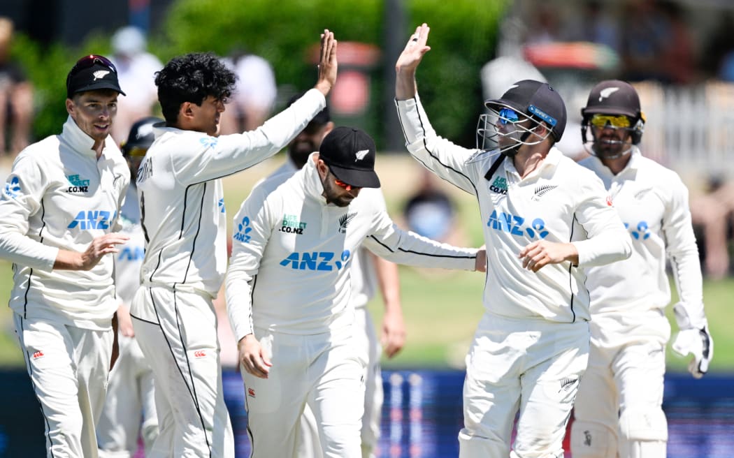 Rachin Ravindra and Tom Latham celebrate the wicket of South Africa's Keegan Petersen on day three of the first cricket test between New Zealand and South Africa.