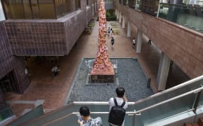 Visitors look at the eight-meter 'Pillar of Shame' statue that commemorates the victims of the 1989 Tiananmen Square crackdown in Beijing, at the University of Hong Kong (HKU) in Hong Kong, on 11 October, 2021.
