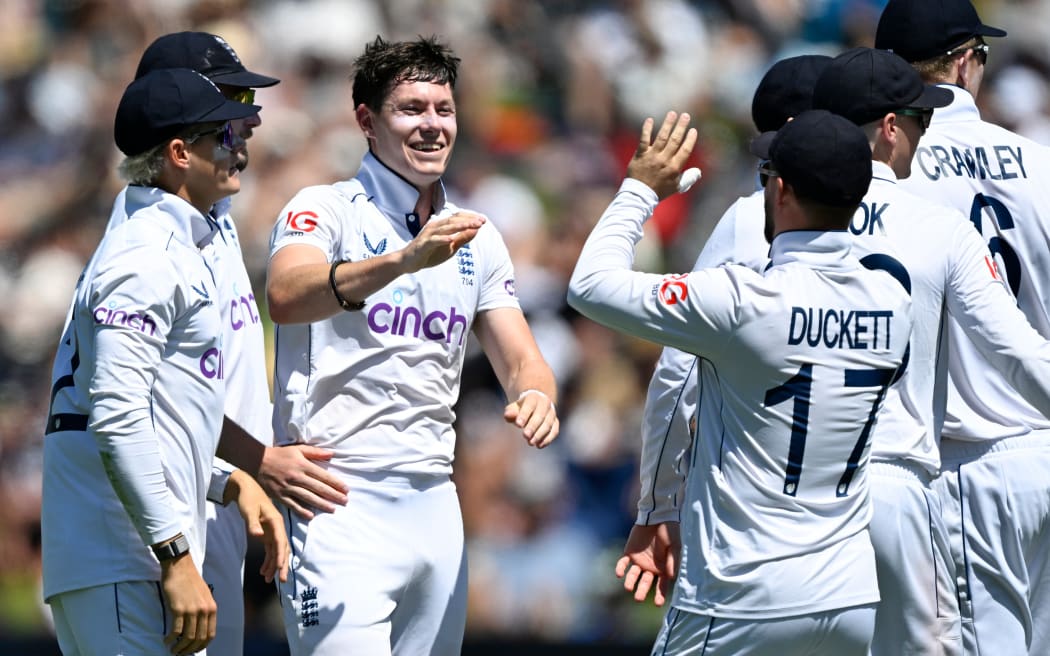 England bowler Matthew Potts celebrates with team mates the wicket of Tom Latham.