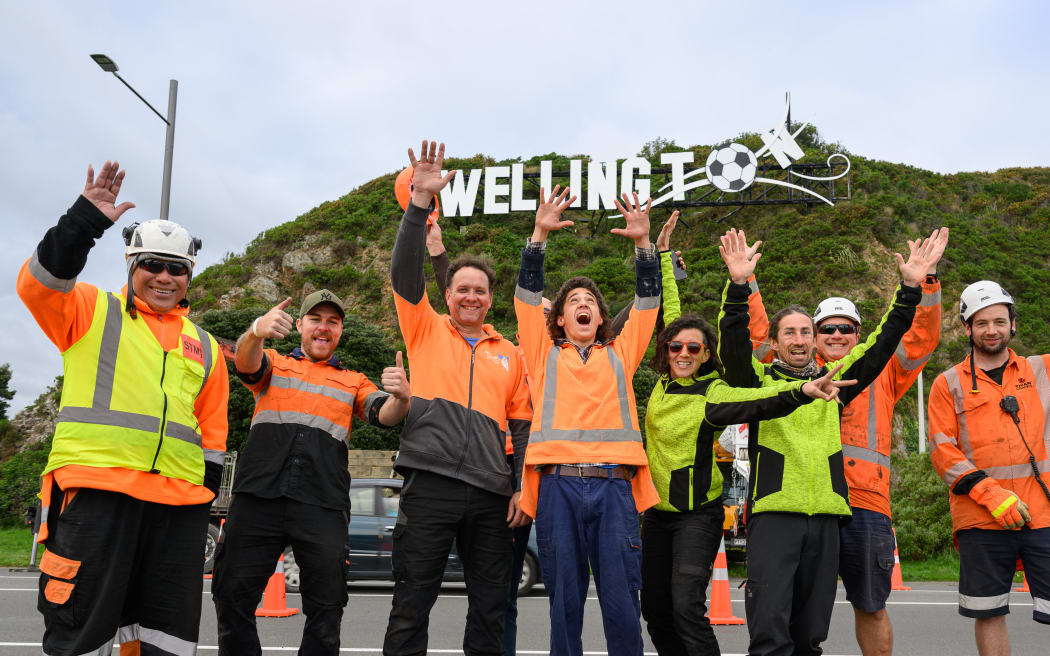 Workers celebrating the installation of a football on the Wellington sign to celebrate the Women’s Football World Cup event on 27 June 2023 in the capital.