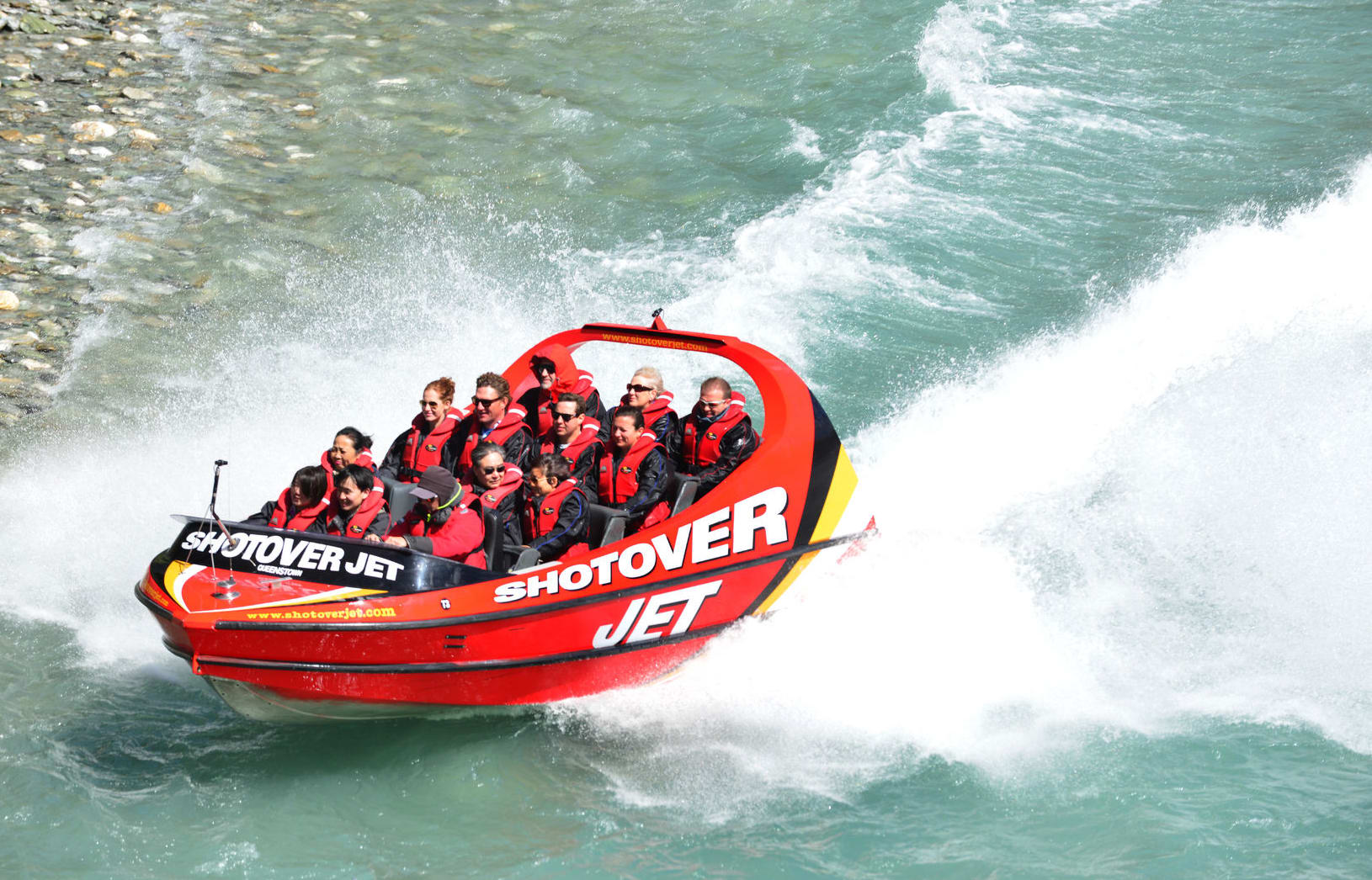 Tourists enjoy a high-speed boat ride on Queenstown