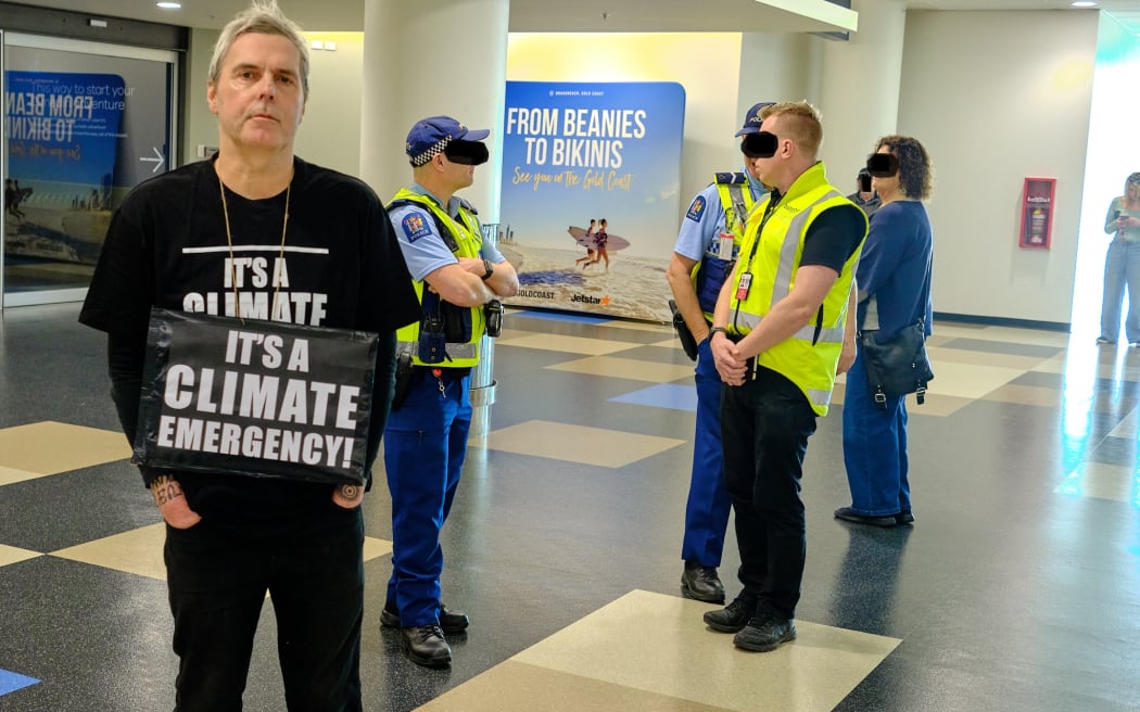 Bruce Mahalski was convicted and discharged after trespassing at the Dunedin Airport while wearing a shirt saying 'It's a Climate Emergency' and holding a protest sign. Photo: Supplied