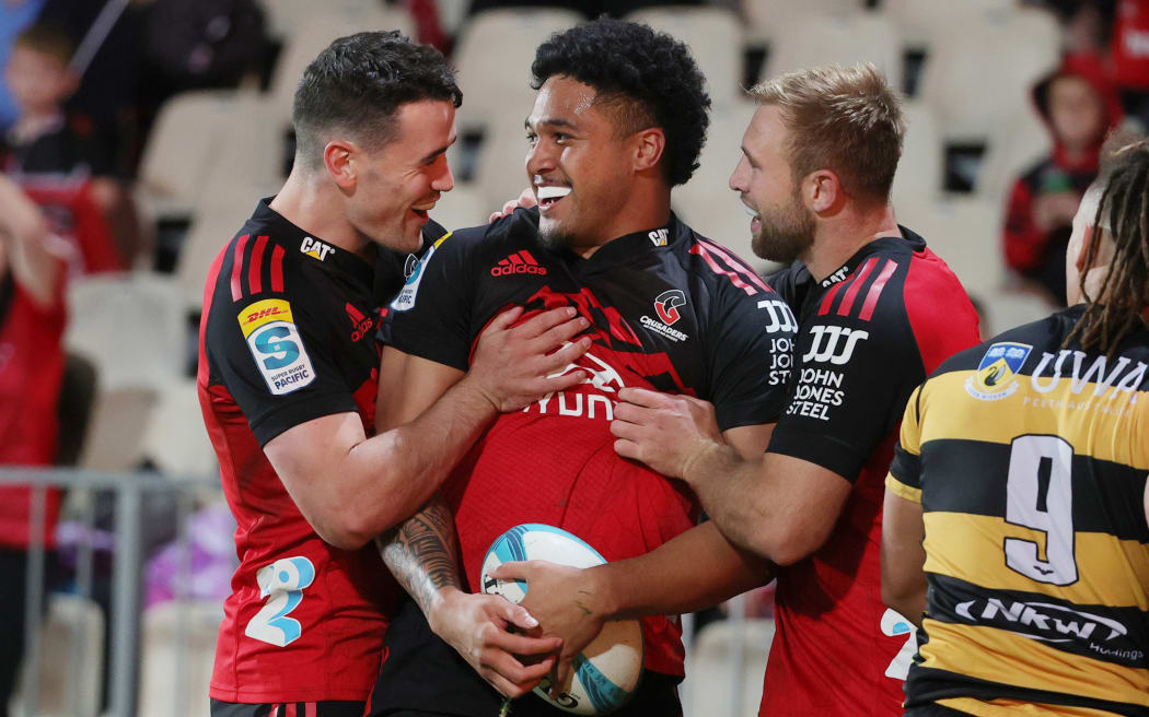 Crusaders winger Leicester Fainga'anuku is congratulated by teammates, 2023.