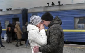 A couple embrace as they stand in front of an evacuation train at the central train station in Odessa on 6 March, 2022.