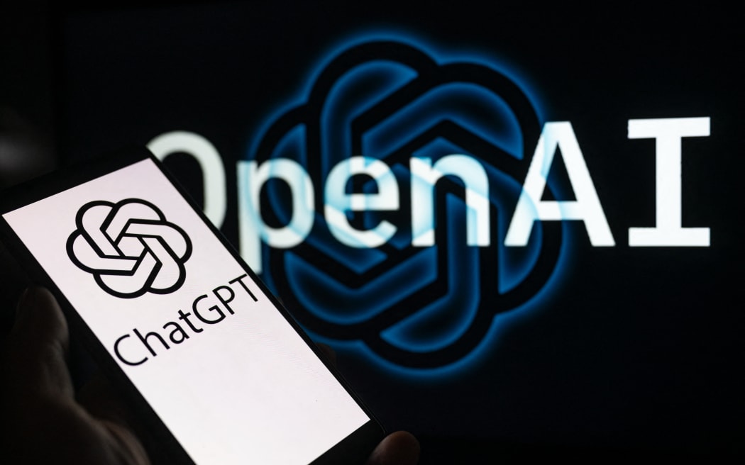 A smartphone displaying ChatGPT with the OpenAI logo in the background is being shown in this photo illustration in Brussels, Belgium, on 3 December, 2023.