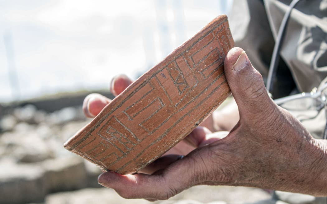Handout picture released by the Peruvian Ministry of Culture on August 27, 2023 showing an archaeologist holding a pottery piece found at a 3,000-year-old priest's tomb, found by a group of Japanese and Peruvian archaeologists under a ceremonial site at the Pacopampa archeological site, in Cajamarca, northeast of Peru. (Photo by Handout / Peruvian Ministry of Culture / AFP) / RESTRICTED TO EDITORIAL USE - MANDATORY CREDIT "AFP PHOTO / PERUVIAN MINISTRY OF CULTURE " - NO MARKETING - NO ADVERTISING CAMPAIGNS - DISTRIBUTED AS A SERVICE TO CLIENTS