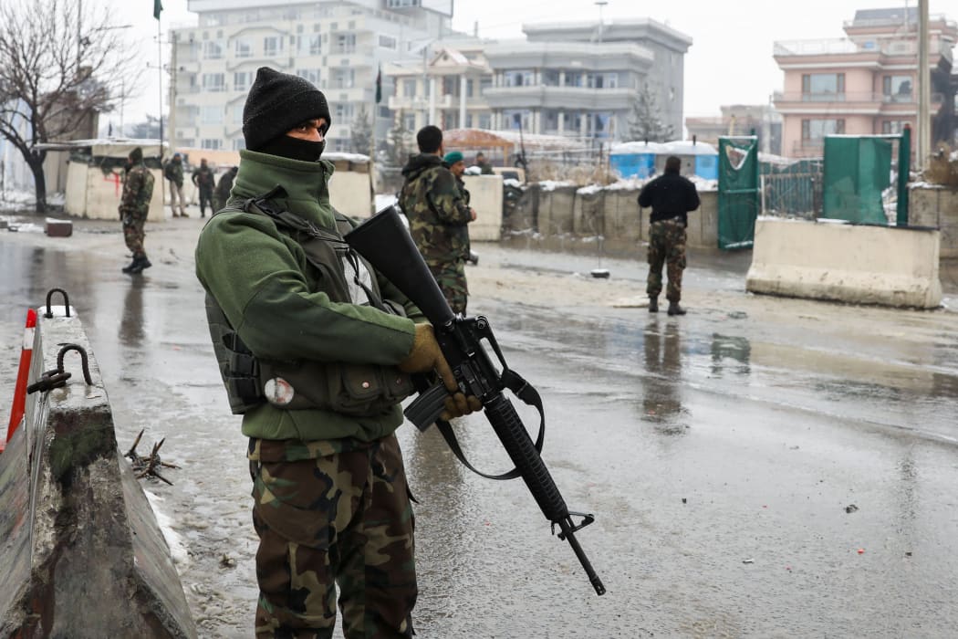 Afghan security personnel stand guard an area following a suicide attack near the Marshal Fahim Military Academy base in Kabul.
