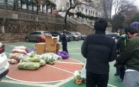 Members of the International Students Office at Wuhan University of Technology provide vegetables to students who have remained on campus.