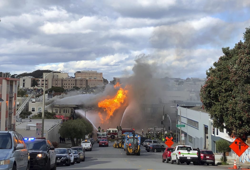 Flames rage at an intersection in San Francisco, Wednesday, Feb. 6, 2019. An explosion on a gas line has set at least one San Francisco building on fire