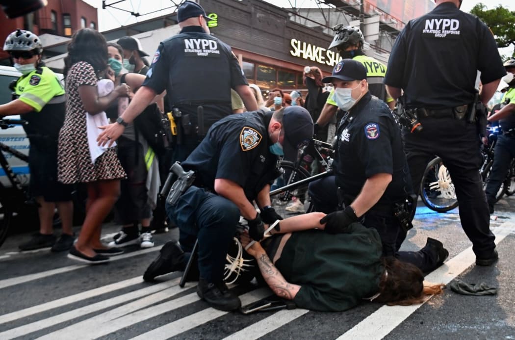 Police officers cuff a protestor during a "Black Lives Matter" protest near Barclays Center on May 29, 2020 in the Brooklyn borough of New York City, in outrage after George Floyd, an unarmed black man, died while being arrested