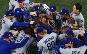 TORONTO, ONTARIO - NOVEMBER 02: Pitcher Yoshinobu Yamamoto #18 of the Los Angeles Dodgers (R) celebrates with teammates after defeating the Toronto Blue Jays, 5-4, in game seven of the 2025 World Series at Rogers Center on November 02, 2025 in Toronto, Ontario.   Patrick Smith/Getty Images/AFP (Photo by Patrick Smith / GETTY IMAGES NORTH AMERICA / Getty Images via AFP)