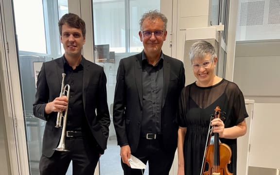 Tom Wilkinson stands to the left of his parents, Tim Wilkinson and Lynette Murdoch. The three doctors and musicians are co-organisers of the New Zealand Doctors Orchestra.