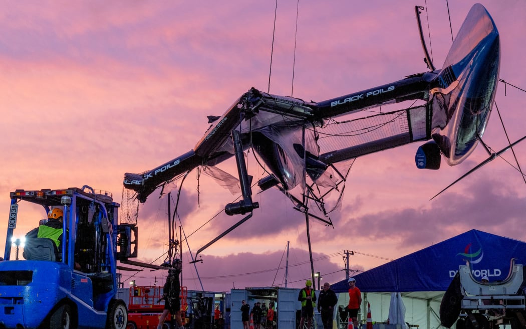 The damaged Black Foils SailGP Team F50 catamaran is craned out of the water on Race Day 1 of the ITM New Zealand Sail Grand Prix in Auckland, New Zealand.