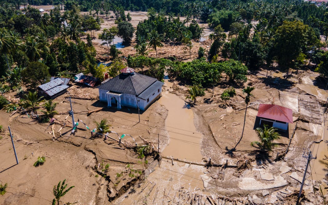 This aerial picture shows a mosque standing amid mud in a flood affected area amid flash floods in Meureudu, Pidie Jaya district Indonesia's Aceh province on November 30, 2025.