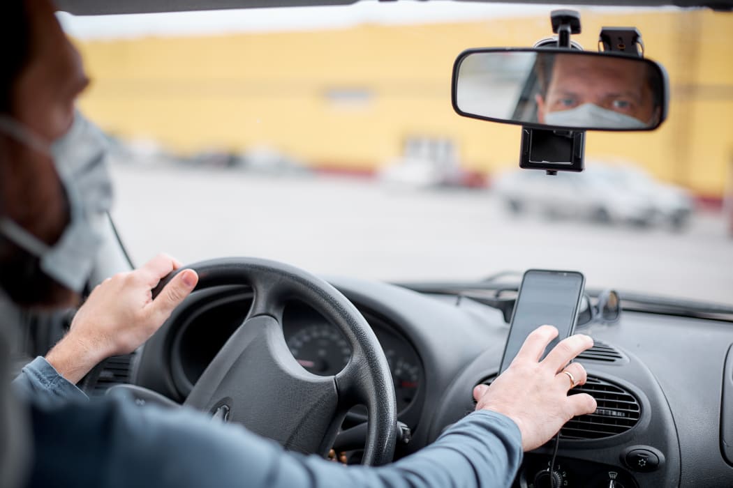 Taxi driver using phone for navigation.