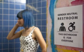A non-binary femme in a gender neutral bathroom.
