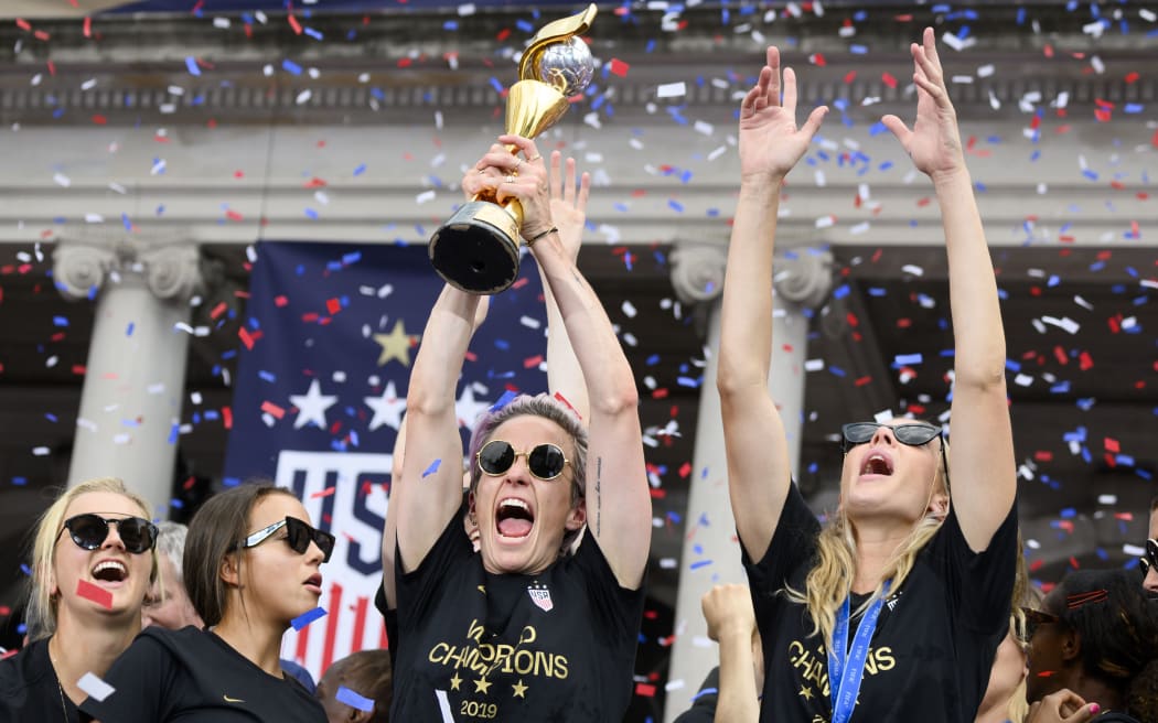 USA women's soccer player Megan Rapinoe (C) and other team members celebrate with the trophy in front of the City Hall after the ticker tape parade for the women's World Cup champions on July 10, 2019 in New York.
