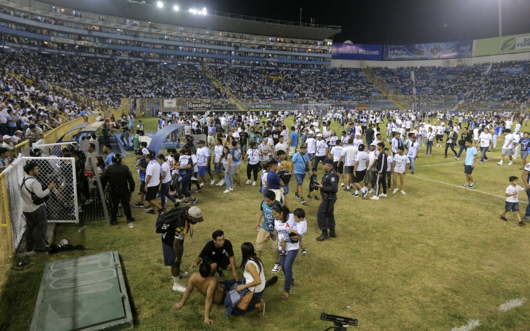 Supporters are helped by others following a stampede during a football match between Alianza and FAS at Cuscatlán stadium in San Salvador, on 20 May, 2023. At least nine people were killed in the stampede, police said.
