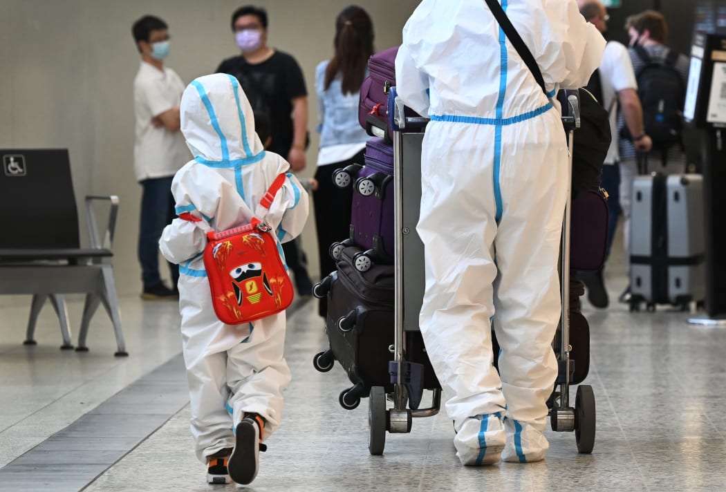 International travellers wearing personal protective equipment (PPE) arrive at Melbourne's Tullamarine Airport on November 29, 2021 as Australia records it's first cases of the Omicron variant of Covid-19.