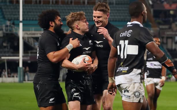 Damian McKenzie (C) scores a try which was disallowed as he celebrates with Jordie Barrett (R) and Fehi Fineanganofo (L).