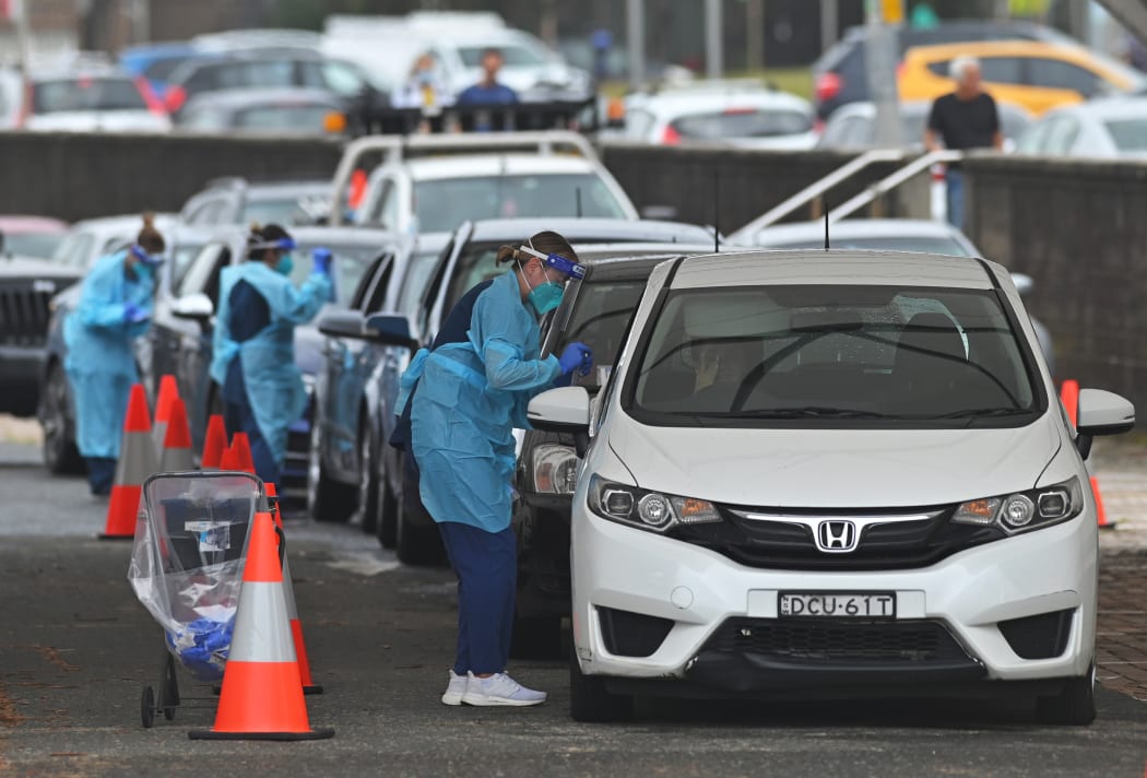 Health workers perform Covid-19 tests at a drive-through testing centre at Bondi Beach in Sydney on December 20, 2020.