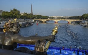 Athletes dive and swim in the Seine River from Paris' Alexander III bridge during a triathlon test event for the Olympics Games on 17 August, 2023.
