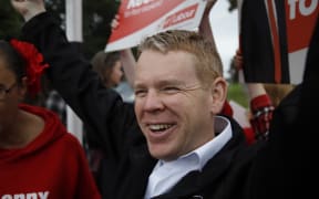 Labour Party leader Chris Hipkins holding up a sign while campaigning in Ōtara on 7 October 2023.