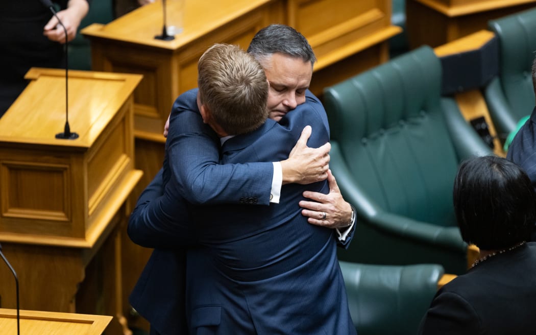 Labour Leader Chris Hipkins embraces Green Co-Leader James Shaw in Parliament after their tributes to Efeso Collins.