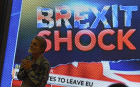 An Indian pedestrian gestures as he stands near a large screen showing news of Britain's vote to exit the European Union in Mumbai on 24 June 2016.