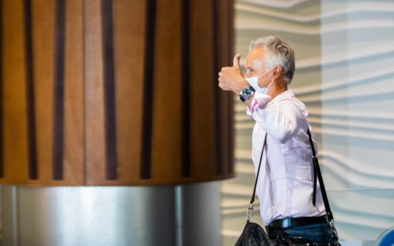A passenger gives a thumbs-up as he walks into the arrivals hall after flying from Sydney to Auckland Airport.