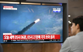 A man watches a television news screen showing file footage of a North Korean missile launch, at a railway station in Seoul on 31 July, 2019.