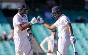 India's Ravichandran Ashwin (L) and teammate Hanuma Vihari touch gloves during the fifth day of the third cricket Test match between Australia and India at the Sydney Cricket Ground (SCG) in Sydney on January 11, 2021.