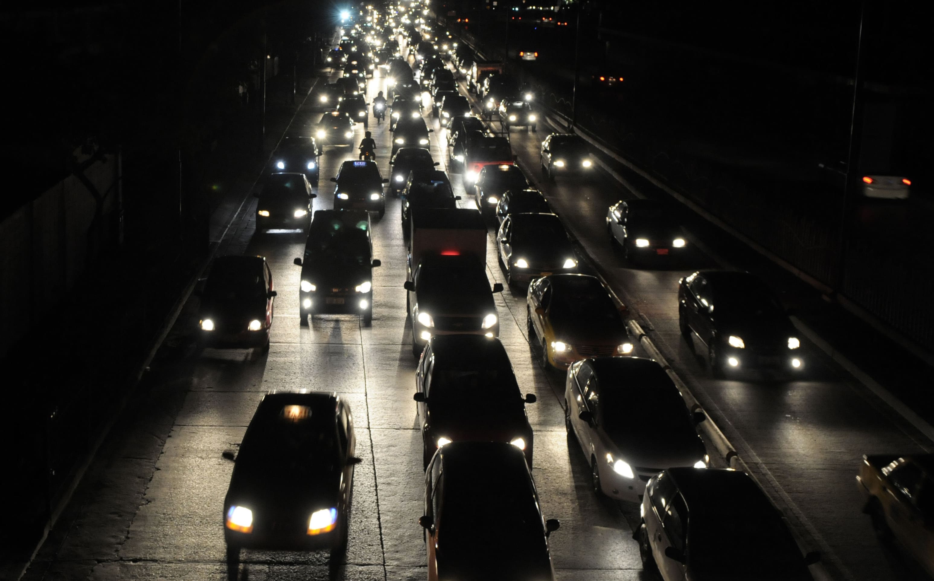 Cars travel on a darkened street as power was cut following a 7.8 quake in Ecuador.