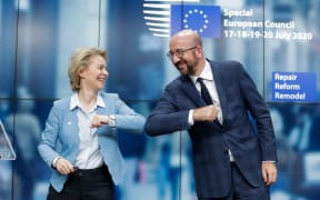 European Commission President Ursula Von Der Leyen (L) and European Council President Charles Michel (R) bump elbows at the end of the news conference following a four days European summit at the European Council in Brussels, Belgium
