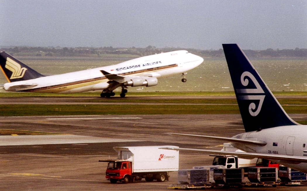 A Singapore airlines jet takes off from Auckland International Airport, 18 September 2001, while a New Zealand airline plane sits on the tarmac. Singapore Airlines is a major shareholder in Air New Zealand and is involved in negotiating a rescue package for New Zealand's embattled carrier.
AFP Photo/Naashon Zalk (Photo by NAASHON ZALK / AFP)