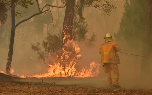 A fireman fights a bushfire to protect a property in Balmoral, 150 kilometres southwest of Sydney on December 19, 2019.