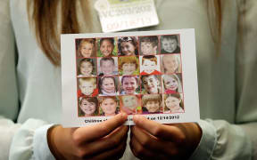 Kyra Murray holds a photo with victims of the shooting at Sandy Hook Elementary School  at the US Capitol calling for gun reform legislation and marking the 9 month anniversary of the shooting September 18, 2013 in Washington, DC.