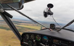 View from the cockpit of a light plane during flight outside.