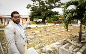 Tonga Parliament's Speaker Lord Fakafanua points out the courts buildings beyond the site where the Parliament building once was.