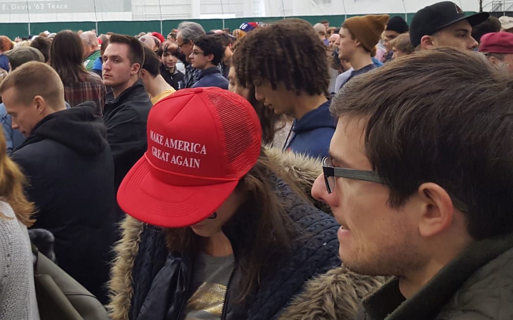 Girl bows head slightly to show of "Make America Great Again" slogan on her red cap