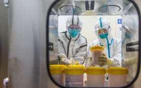 Staff members receive the novel coronavirus strain transported from Zhejiang Provincial Center for Disease Control and Prevention, at a laboratory of Chinese Center for Disease Control and Preventio on Feb. 25, 2020.