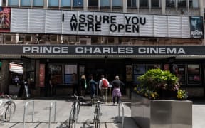 LONDON, UNITED KINGDOM - MAY 17, 2021: People queue outside Prince Charles Cinema as England moves to Step 3 in easing of coronavirus restrictions, on 17 May, 2021 in London, England.