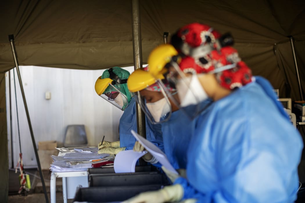 Health workers fill out documents before performing tests for Covid-19 on other health workers at a hospital in Johannesburg,