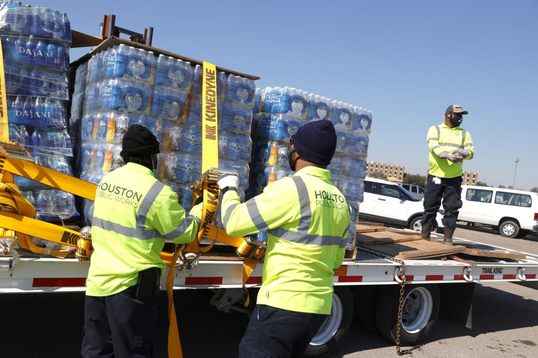 Workers with Houston Public Works unload pallets of water from a truck during a mass water distribution at Delmar Stadium on February 19, 2021 in Houston, Texas. and precipitation. Many Houston residents do not have drinkable water at their homes and are relying on city water giveaways.