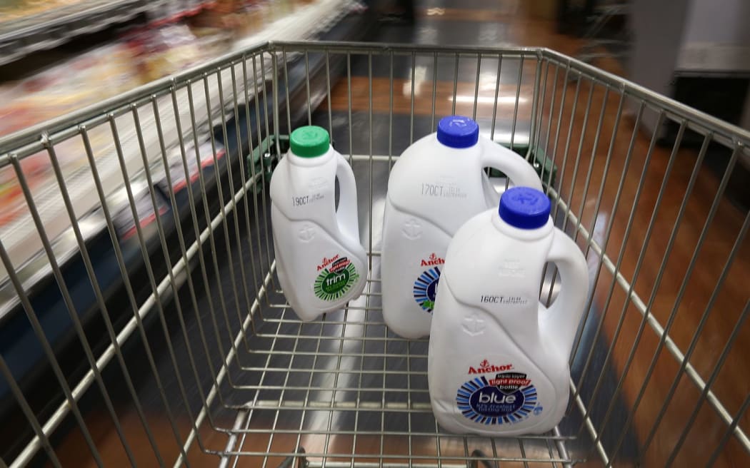 Milk containers in supermarket trolley.