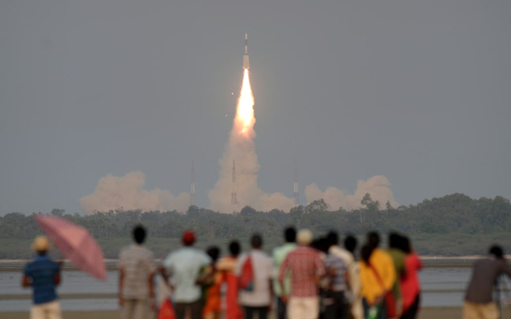 Onlookers watch as the Indian Space Research Organisation's (ISRO) GSAT-6A communications satellite launches.