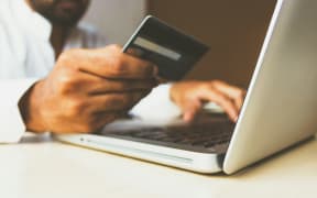 A man entering his credit card details into an online page.